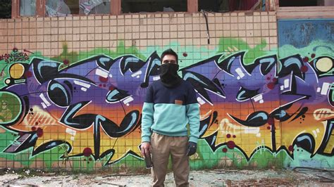 Portrait of young man graffiti artist on graffiti wall background Stock Video Footage - Storyblocks