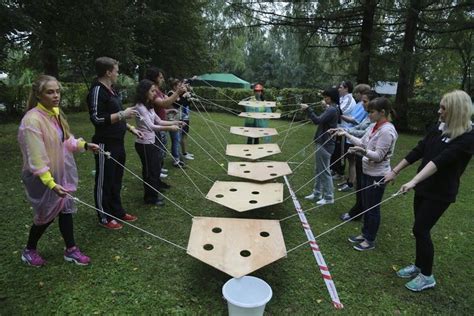 a group of people standing around a wooden board game