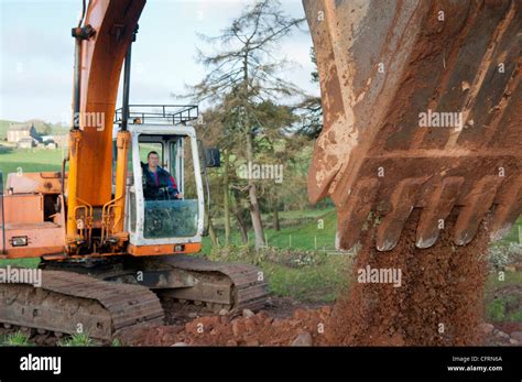 Big excavator digging stone on a hillside Stock Photo - Alamy