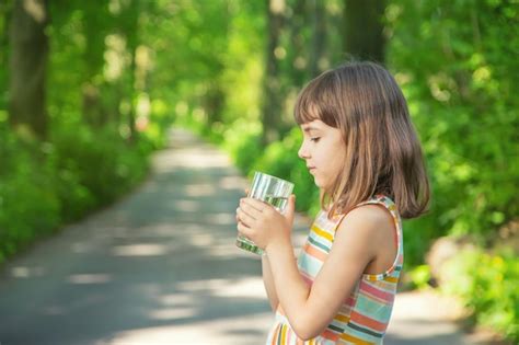 Premium Photo | Cute girl drinking water while standing outdoors