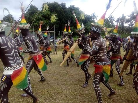 a group of people dressed in black and rainbow colored clothing dancing ...