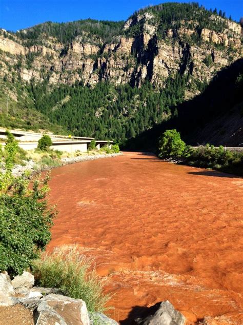 a river with red water and mountains in the background