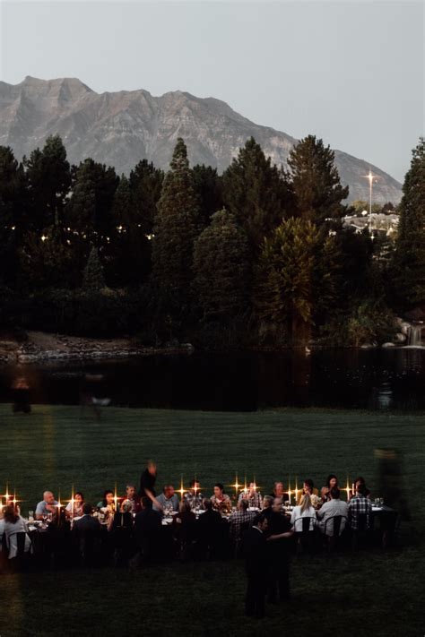 a group of people sitting around a dinner table with candles in front ...