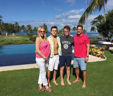 three men and two women standing in front of a pool