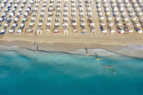 An aerial view of Kathisma beach in Lefkada with people enjoying the deep blue waters. Poster ...