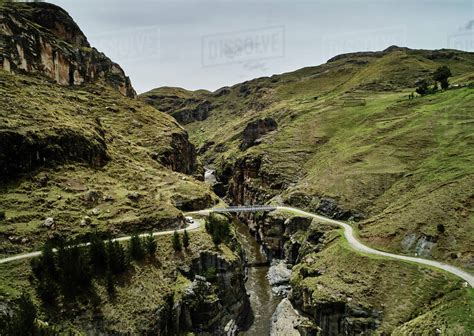 Landscape view of bridge crossing river ravine, Huinchiri, Cusco, Peru - Stock Photo - Dissolve