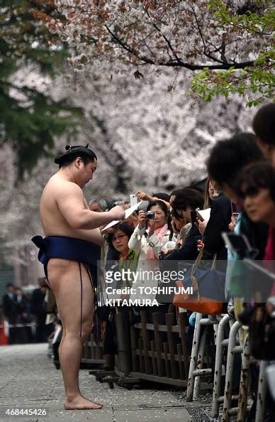 A sumo wrestler signs autographs to fans during a "honozumo," a... News Photo - Getty Images