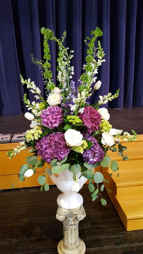 a white vase filled with lots of purple and white flowers