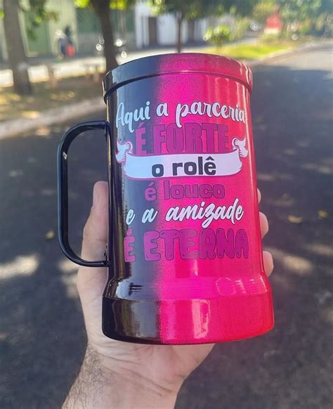 a person holding up a pink and black coffee mug