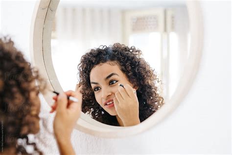 "Young Girl Doing Makeup In Mirror" by Stocksy Contributor "Javier Díez" - Stocksy