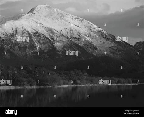 Snow capped Ullock Pike, lit by the setting sun, Bassenthwaite Lake, Lake District National Park ...