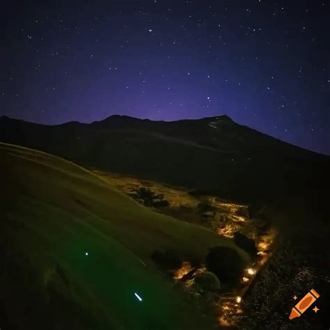 Serene night view from a mountain with glowing stars over rolling hills ...