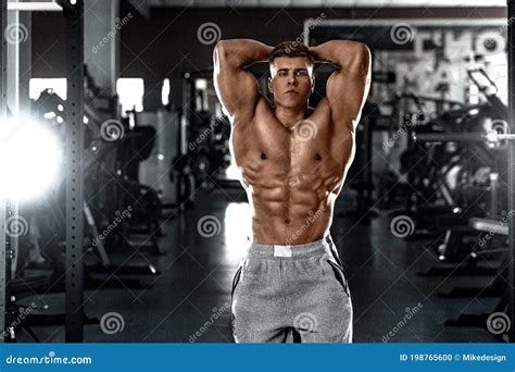 Bodybuilder Athlet Man Pumping Up Muscles in the Gym. Brutal Strong Muscular Guy on Fitness ...