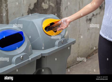 Close up woman hand throwing empty plastic bottle drop in recycling bin ...