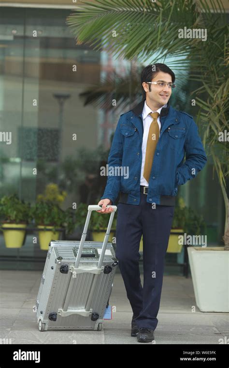 Businessman walking with suitcase Stock Photo - Alamy