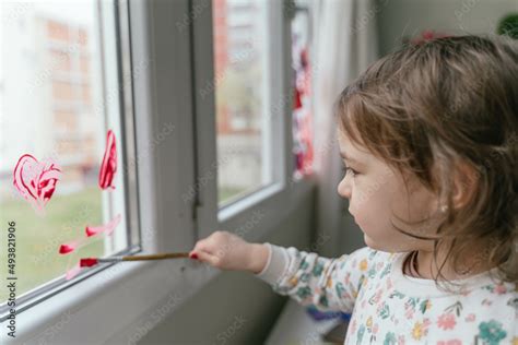 Adorable little girl painting a window Stock Photo | Adobe Stock