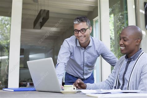 Young men working on the laptop and smiling - Stock Image - F034/2442 - Science Photo Library