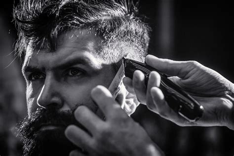 Premium Photo | Hands of barber with hair clipper. Barber works with ...