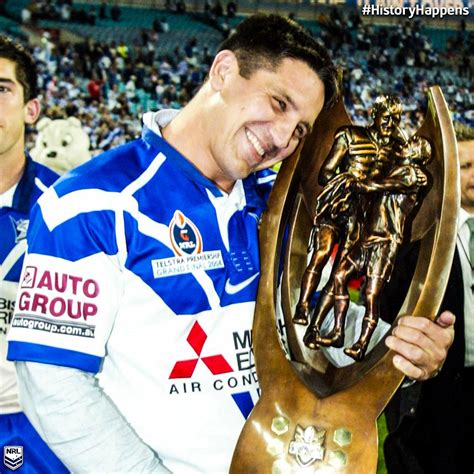 a man is holding up a trophy in front of an audience at a sporting event