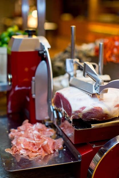 Premium Photo | Close-up of meat and slicing machine on table