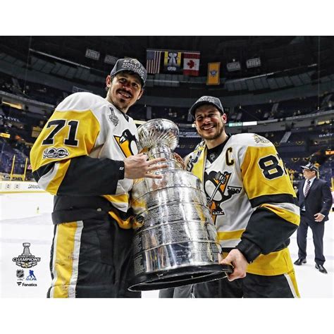 two hockey players pose with the stanley cup