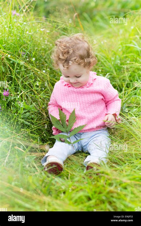 Funny baby girl playing with a snail in the garden on a warm and sunny autumn day Stock Photo ...