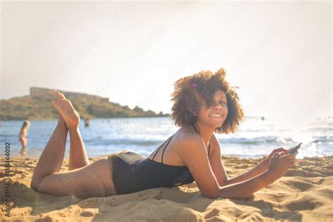 Girl lying down at the beach Stock Photo | Adobe Stock