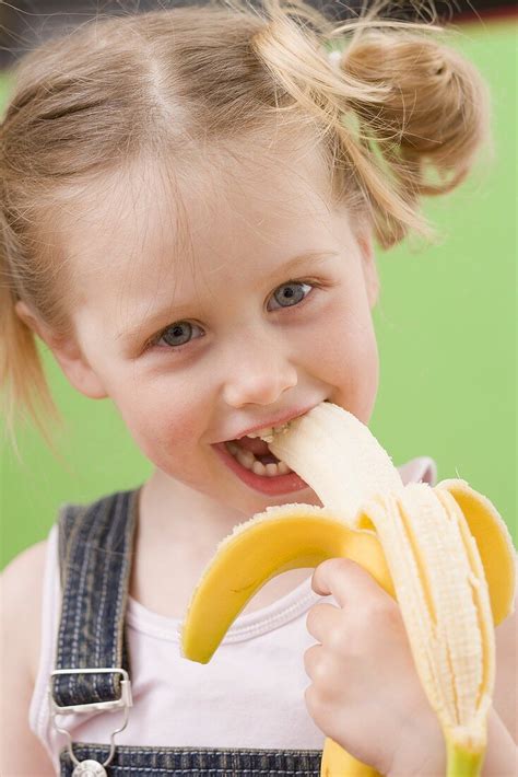 Little girl eating banana – License Images – 969917 StockFood