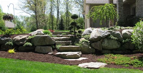 boulder retaining wall with plantings. found on google images from Angie's List. This could work ...