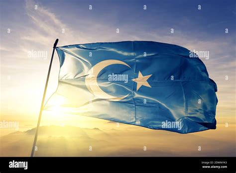 East Turkestan flag waving on the top sunrise mist fog Stock Photo - Alamy