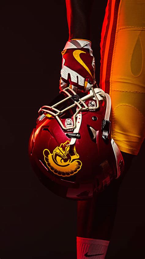 Download USC Football Player Holding Helmet Wallpaper | Wallpapers.com