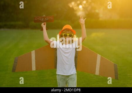 Portrait of child with toy paper wings outdoor. Success, creative and ...