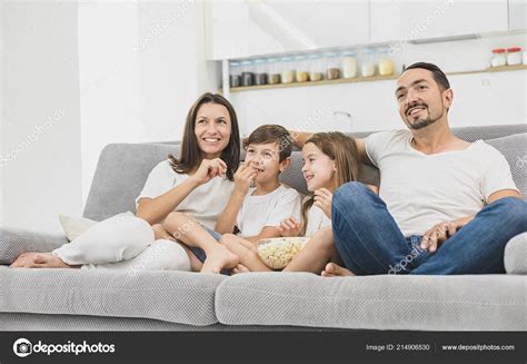 Young family watching TV together at home and having fun together Stock ...
