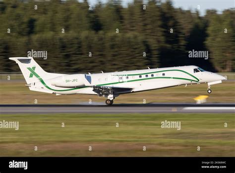 A Embraer Legacy 600 business jet landing on a runway Stock Photo - Alamy