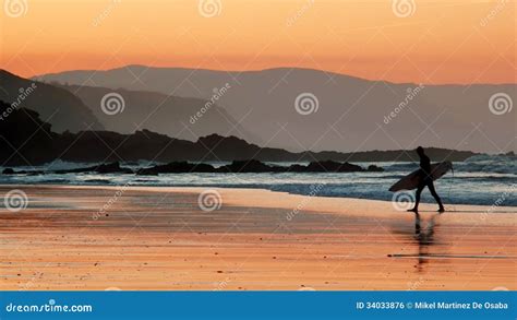 Surfer on beach at sunset stock photo. Image of rider - 34033876