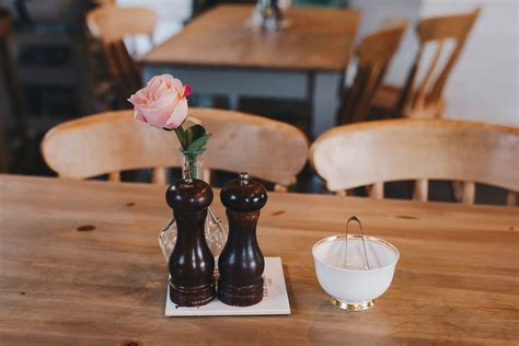 Coffee with cream, cinnamon sticks, sugar cubes, spices and coffee beans on a wooden table ...