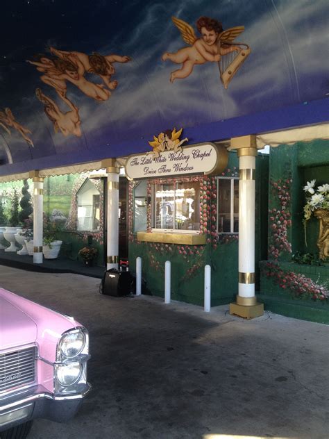 a pink car parked in front of a building with angels painted on the ...