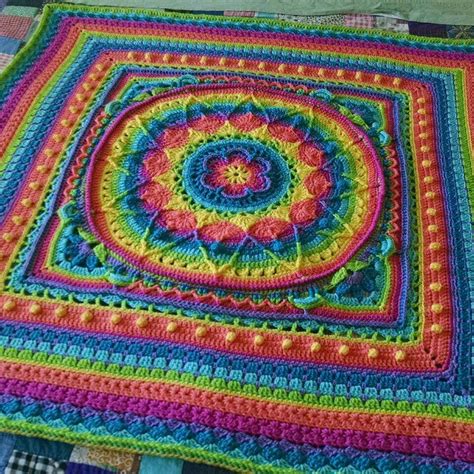 a colorful crocheted blanket on top of a bed