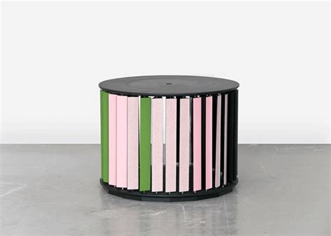 a black table with pink, green and white stripes on the top sitting on a gray floor