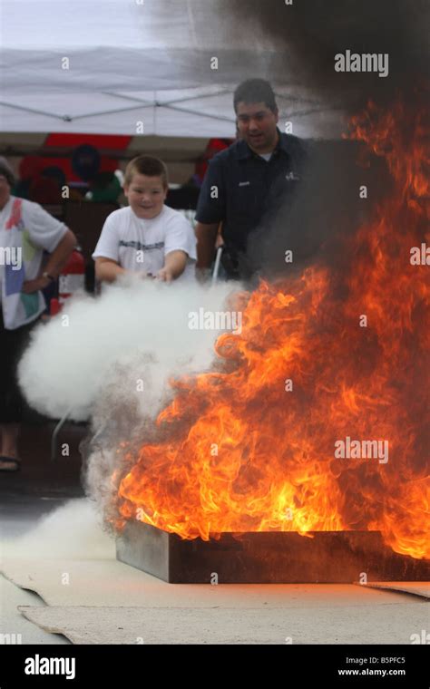 Child using a fire extinguisher to extinguish the flames on a display ...