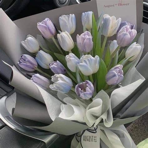 a bouquet of tulips is wrapped in white paper and tied to a car ...