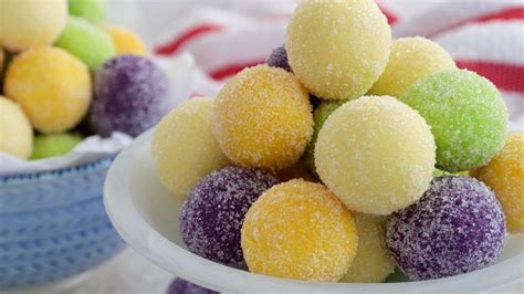 two bowls filled with different colored candies on top of a white cloth ...