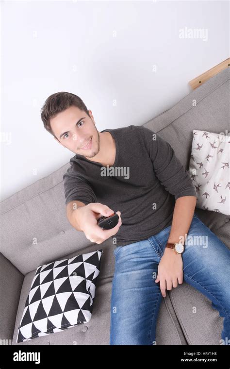 Attractive young man watching tv and relaxed on couch. Indoors Stock ...