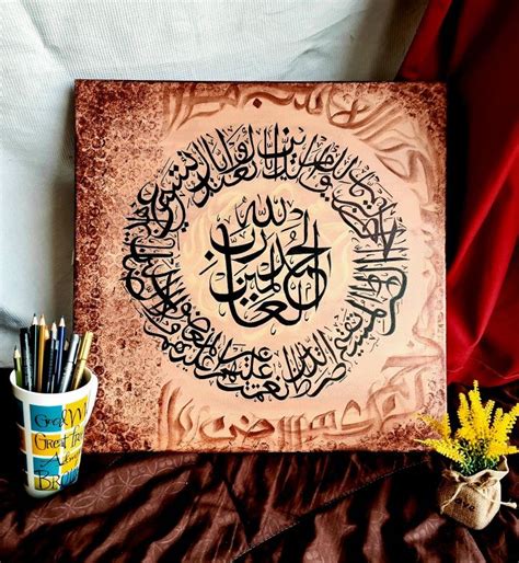 an arabic calligraphy is displayed on a bed with a vase and pen holder ...