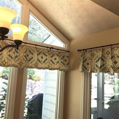 two windows with curtains hanging from them in front of a light fixture ...