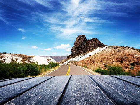 Scenic View of Mountain Road Against Blue Sky · Free Stock Photo