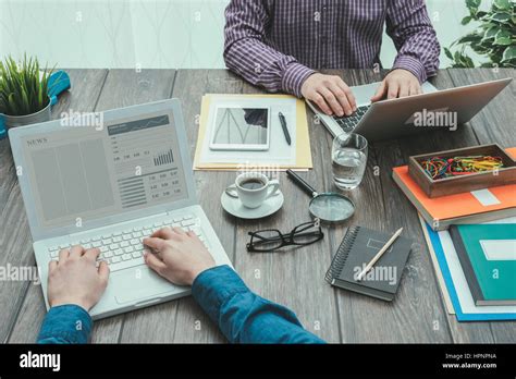 Business people working at office desk, they are using a laptop and networking, point of view ...