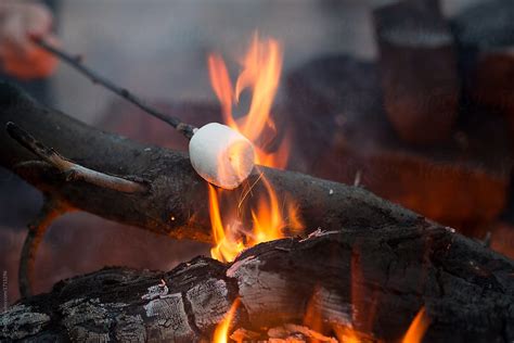 "Roasting Marshmallow On A Stick In A Campfire" by Stocksy Contributor "JP Danko" - Stocksy