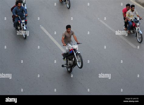 Youth ride on one-wheel motorcycle doing dangerous stunt at Murree road in Rawalpindi. (Photo by ...