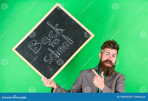 Teacher Welcomes Students while Holds Chalkboard Inscription Back To School. Teaching Occupation ...